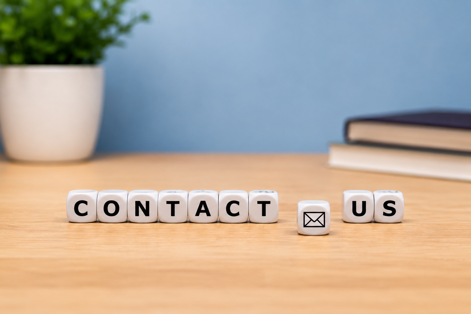 die that spell out contact us on a table.